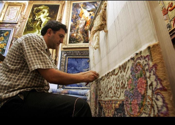 Artisan hand-weaving a Persian rug on a traditional loom